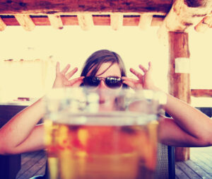 Woman Peaking Over Beer Glass